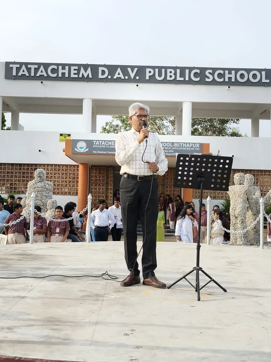 R. K. Sharma addressing the morning assembly in front of the school building